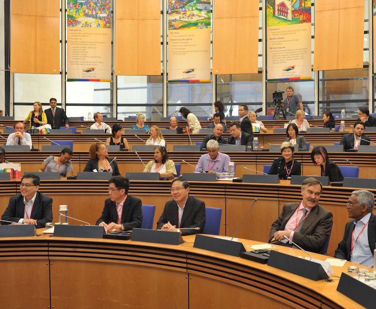Delegates seated in a large council chamber