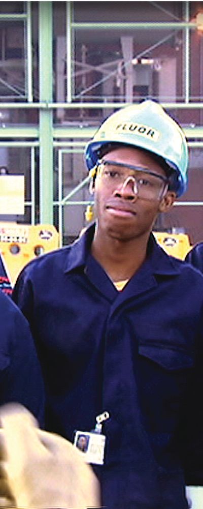A group of workers in overalls and hard hats standing together