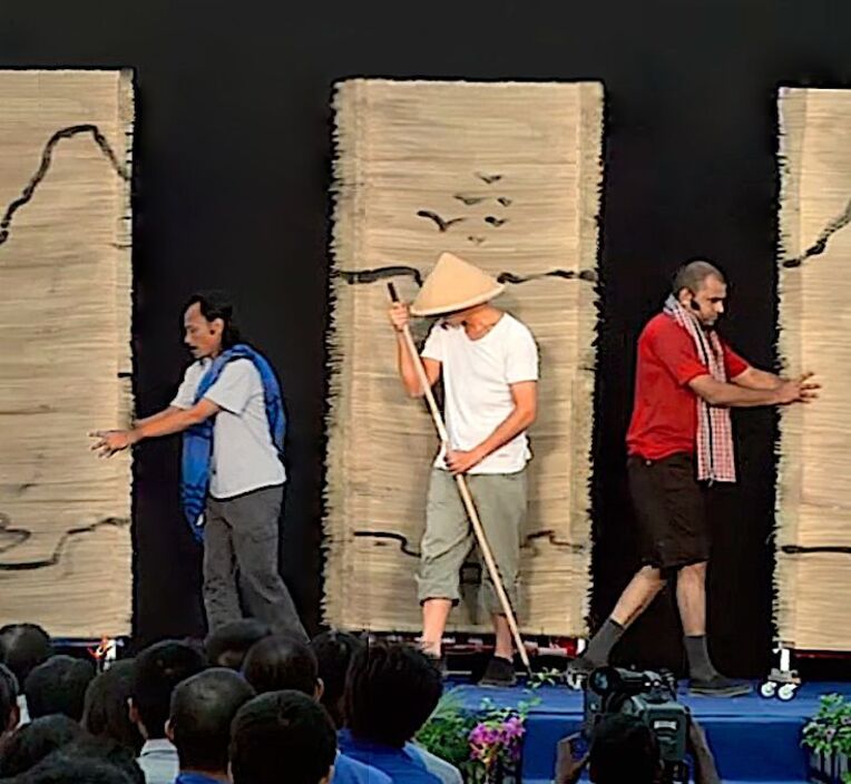 Actors performing on a stage set with painted panels